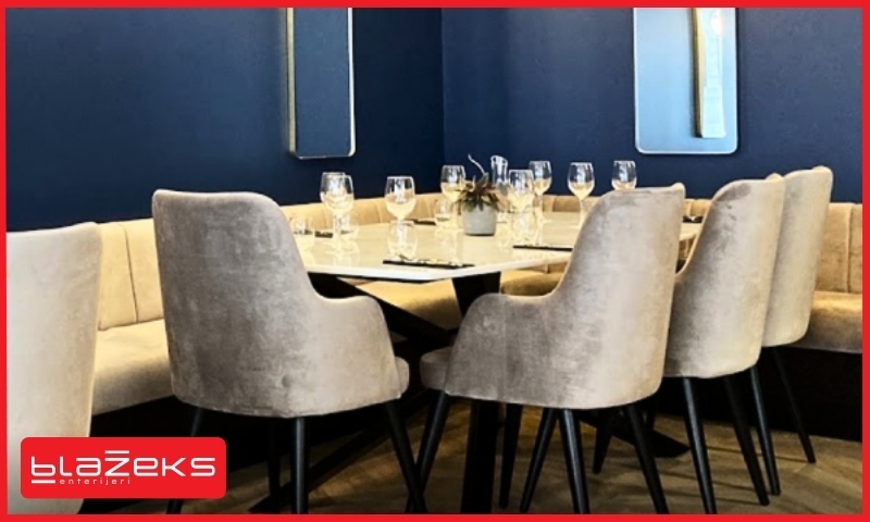 Moderan lokal kafića sa bež tapaciranim stolicama i postavljenim stolovima za goste